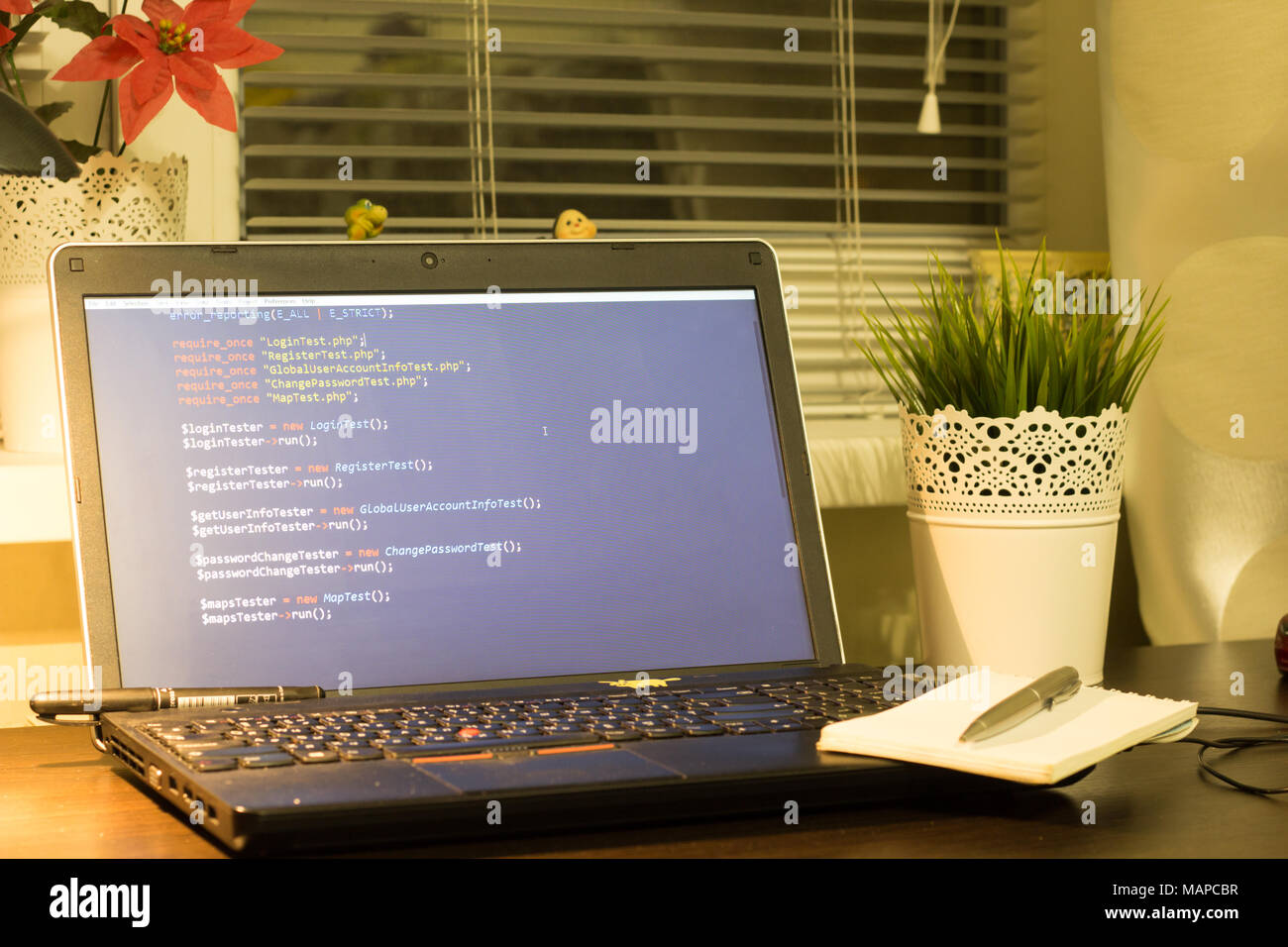 Web developer's workplace. Laptop with a blocknote and a metal pen. Digital technology modern background. Stock Photo