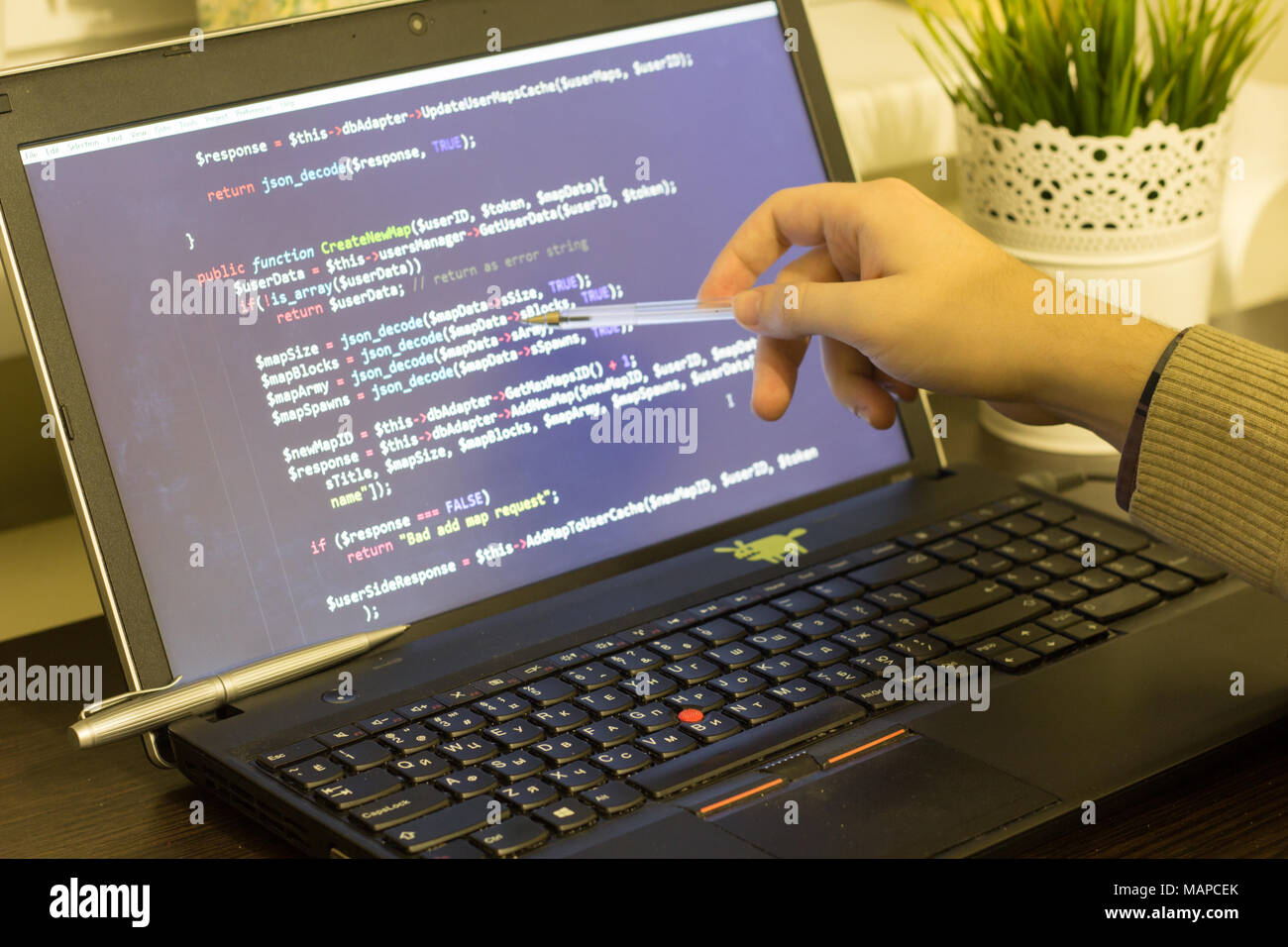 Web developer pointing to PHP code on the screen. Digital technology modern background. Stock Photo