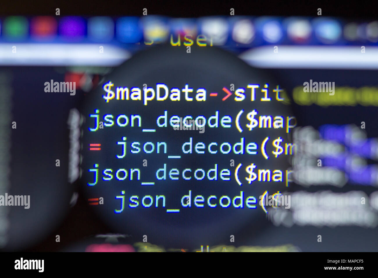 PHP back-end code zoomed through a magnifier. Computer programming source code lookup. Abstract screen of web developer. Stock Photo