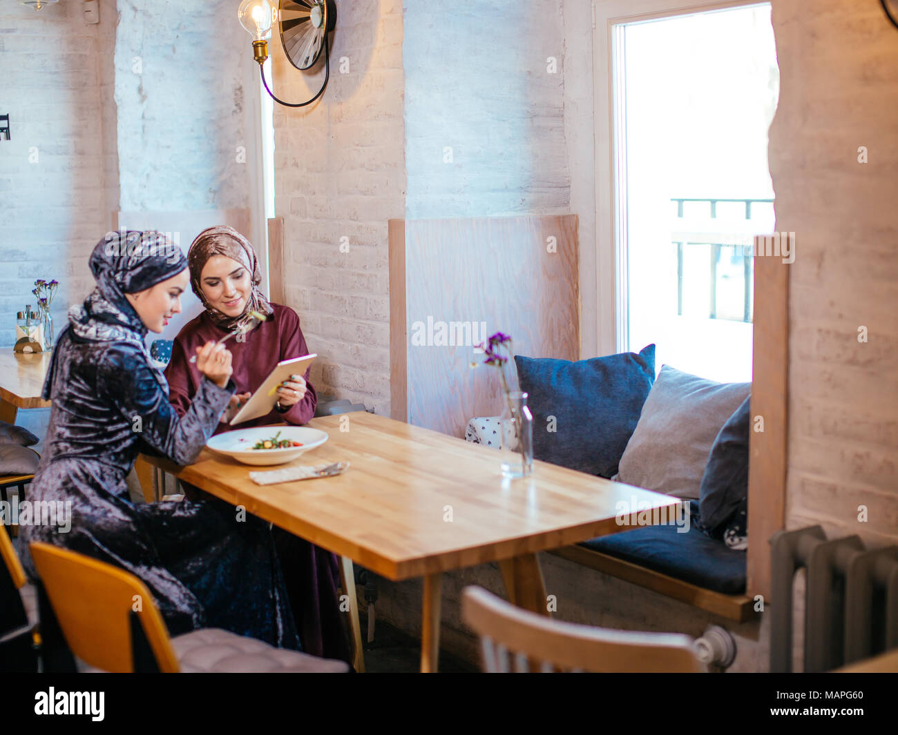 two business partner using tablet in front of their coffee shop Stock