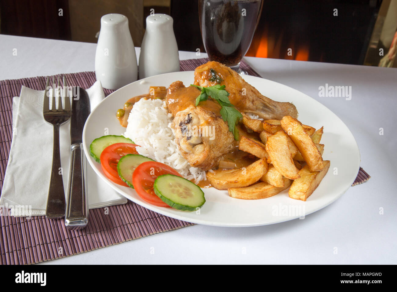 An English pub/restaurant plate of Chicken and boiled rice with chips/fries and English chip
