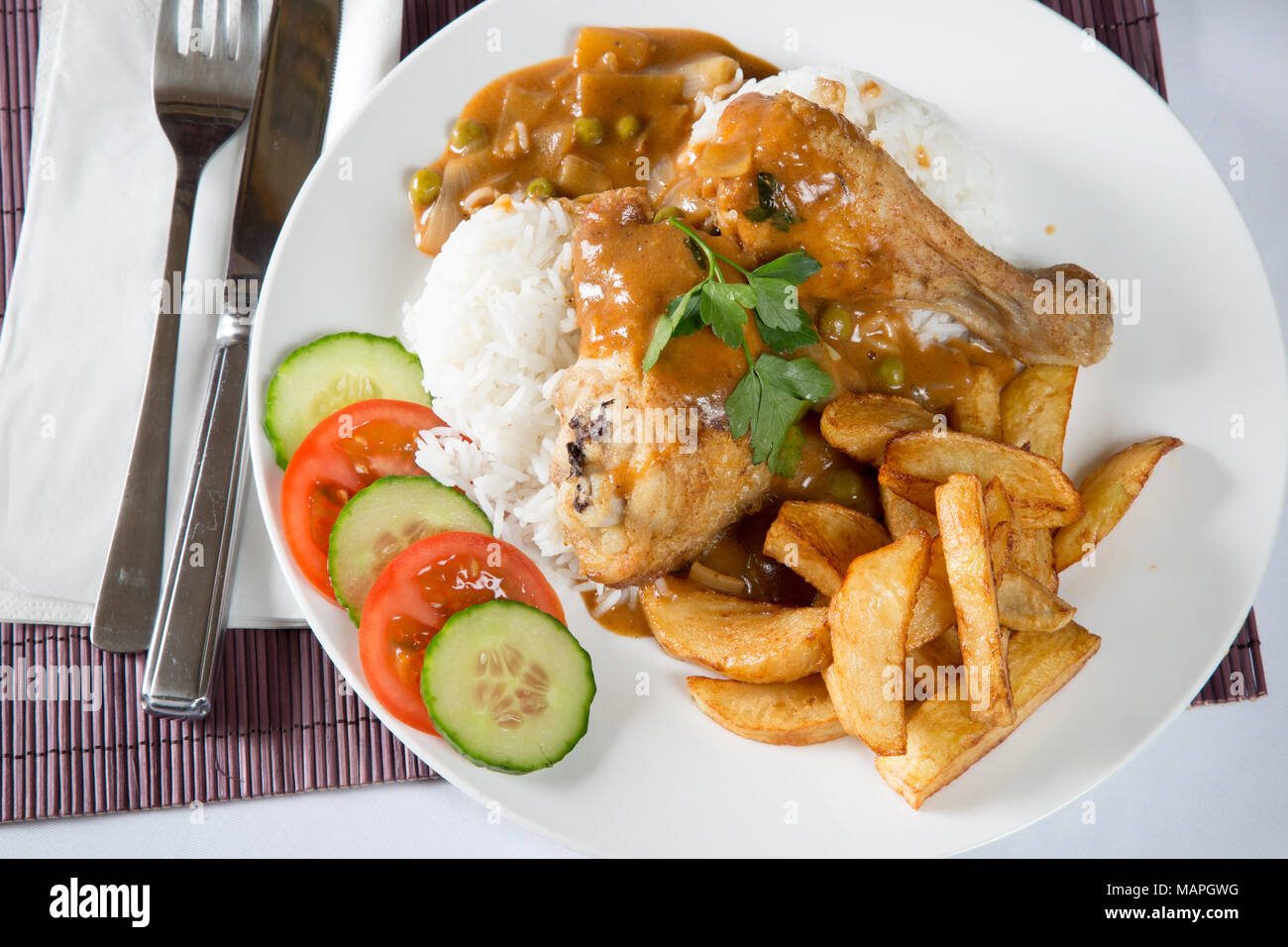 An English pub/restaurant plate of Chicken and boiled rice with chips/fries and English chip