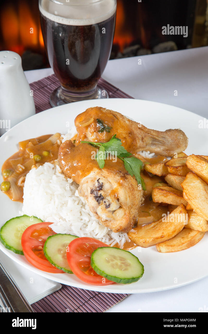 An English pub/restaurant plate of Chicken and boiled rice with chips/fries and English chip