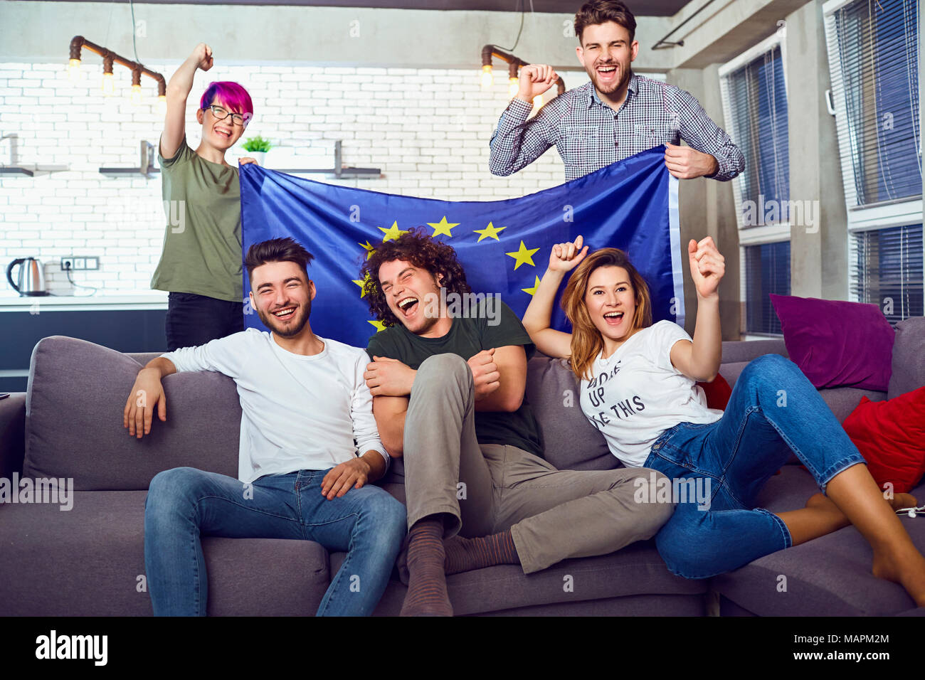 A group of friends with a European flag at a party.  Stock Photo