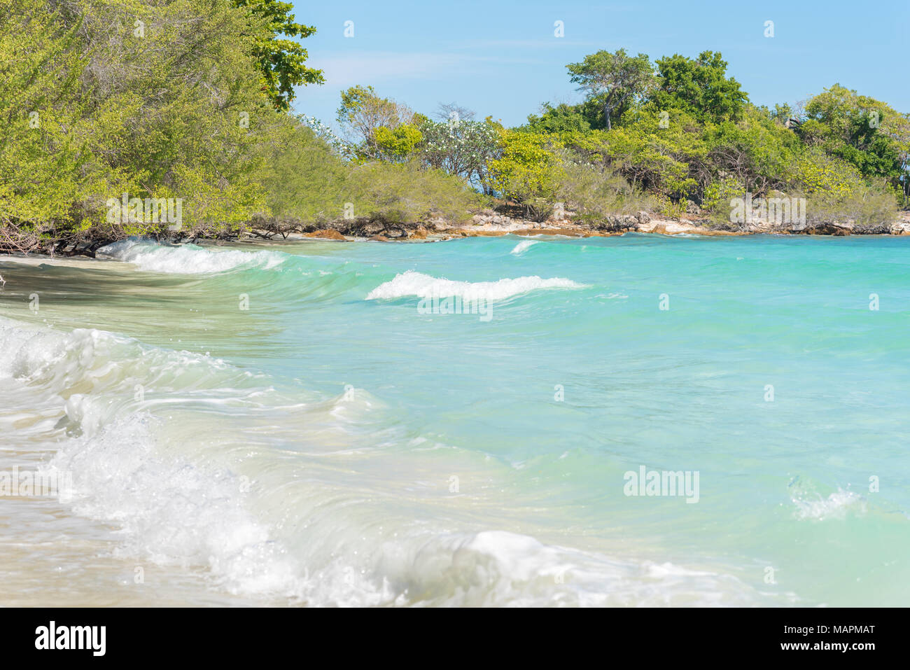 Crystal clear sea water of tropical beach of Ao Wai, Ko Samet (Koh Samed), Thailand in January. Aqua seascape with turquoise waves & lush trees Stock Photo