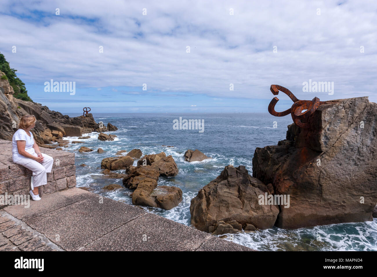 Tourist looking the Comb of the Wind, San Sebastian, Peine del Viento XV, three sculptures by Eduardo Chillida. San Sebastian, Euskadi Stock Photo