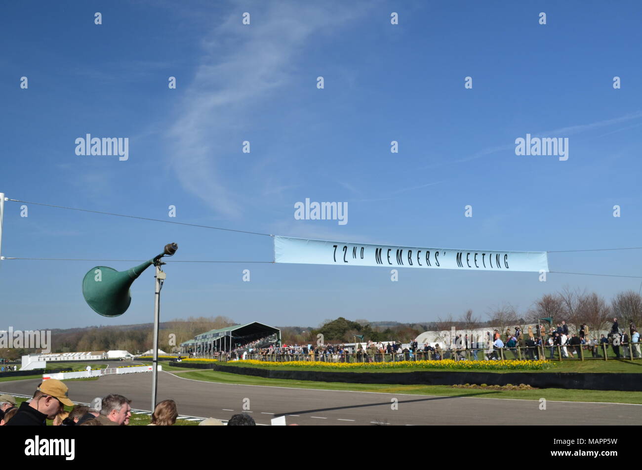 Spectators watch motor racing action at the 72nd Goodwood Members Meeting at the West Sussex motor circuit. Stock Photo