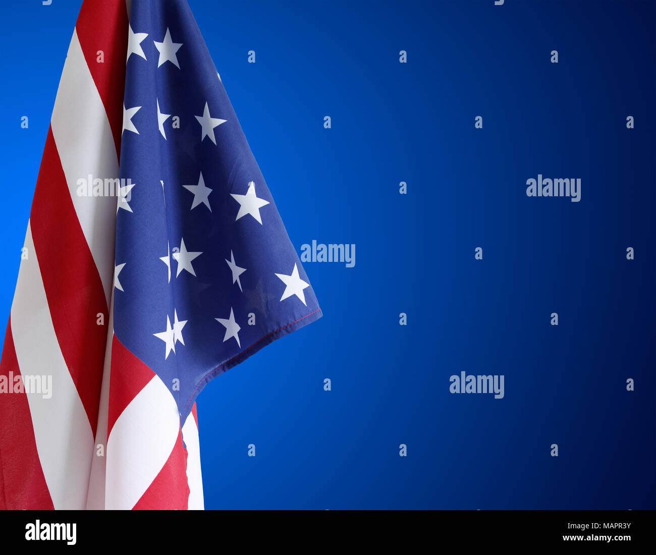 American flag in front of blue background Stock Photo Alamy