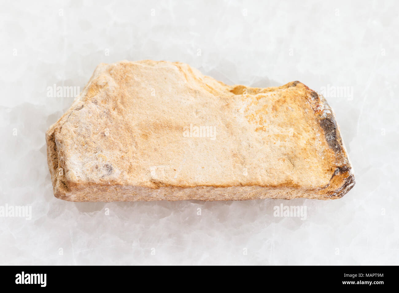 macro shooting of natural mineral rock specimen - raw Shale stone on white marble background Stock Photo