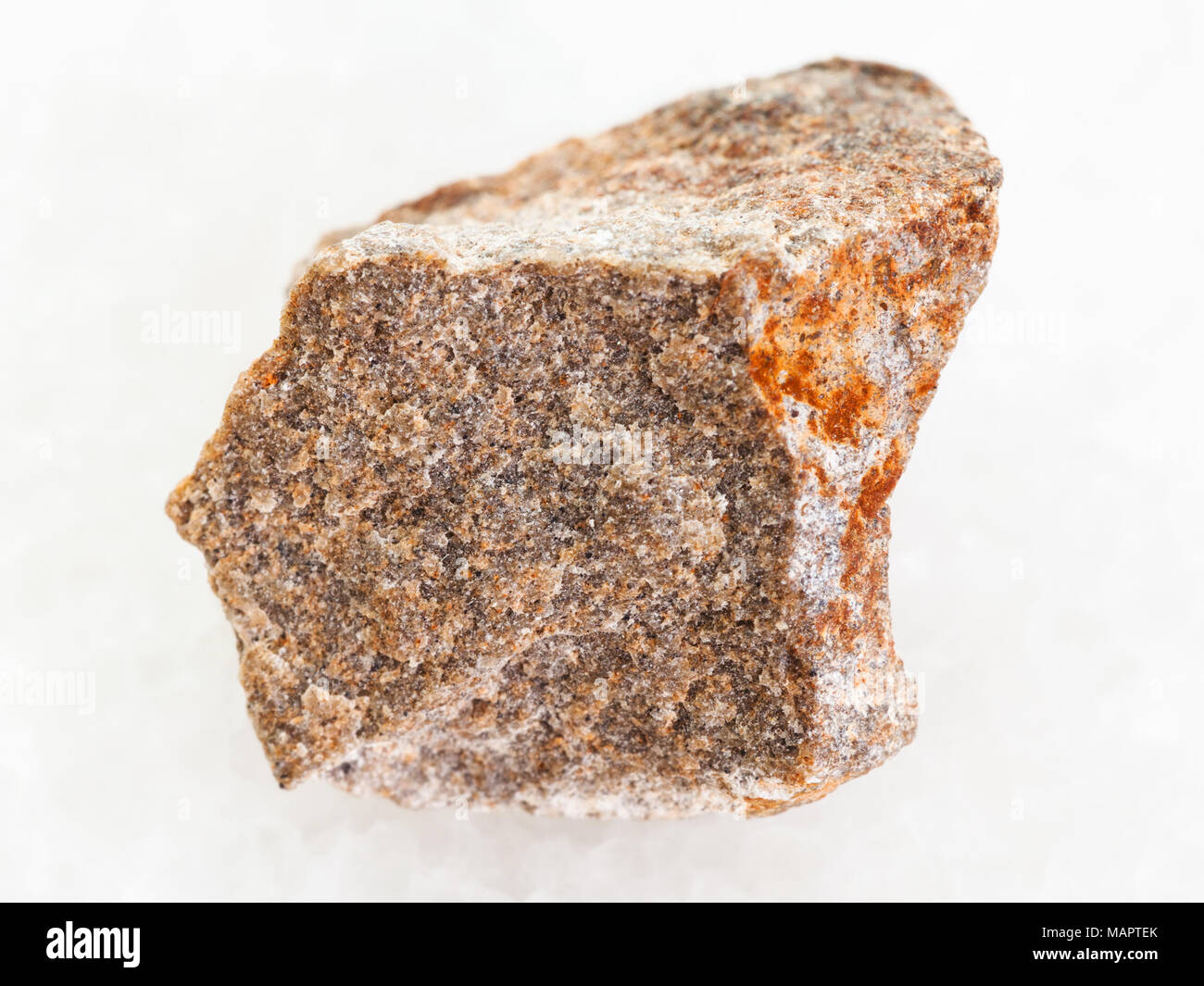 macro shooting of natural mineral rock specimen - rough Quartzite stone on white marble background Stock Photo