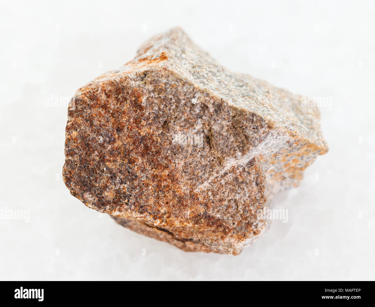 macro shooting of natural mineral rock specimen - raw Quartzite stone on white marble background Stock Photo