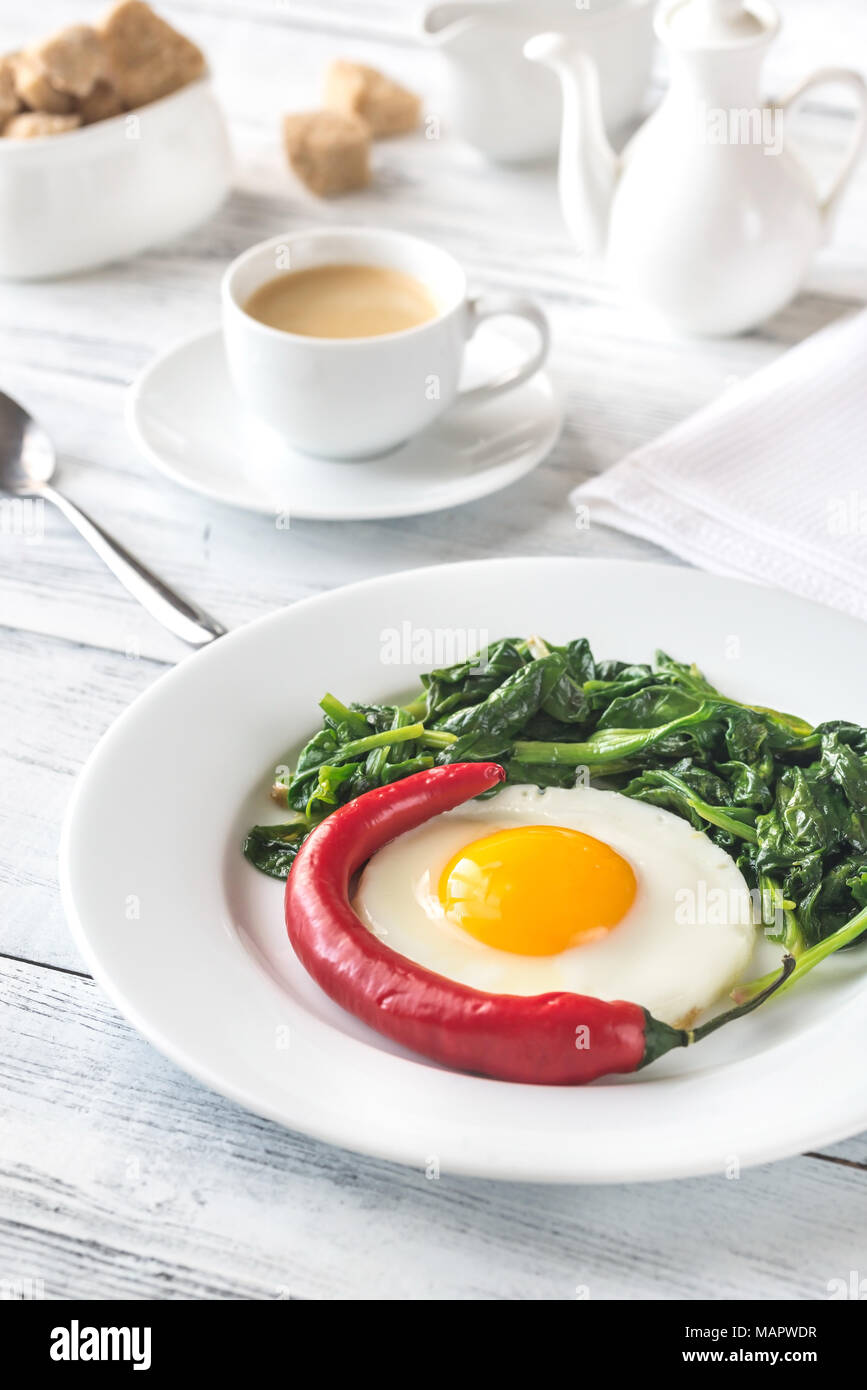 Fried egg with spinach and fresh chilli Stock Photo Alamy