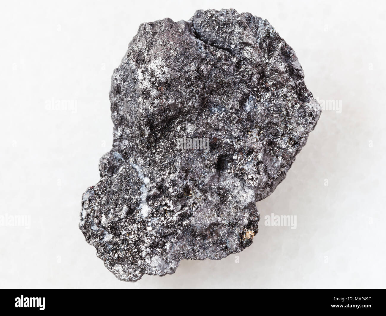 macro shooting of natural mineral rock specimen - piece of Graphite stone on white marble background from Bogotol region of Eastern Sayan Mountains, R Stock Photo
