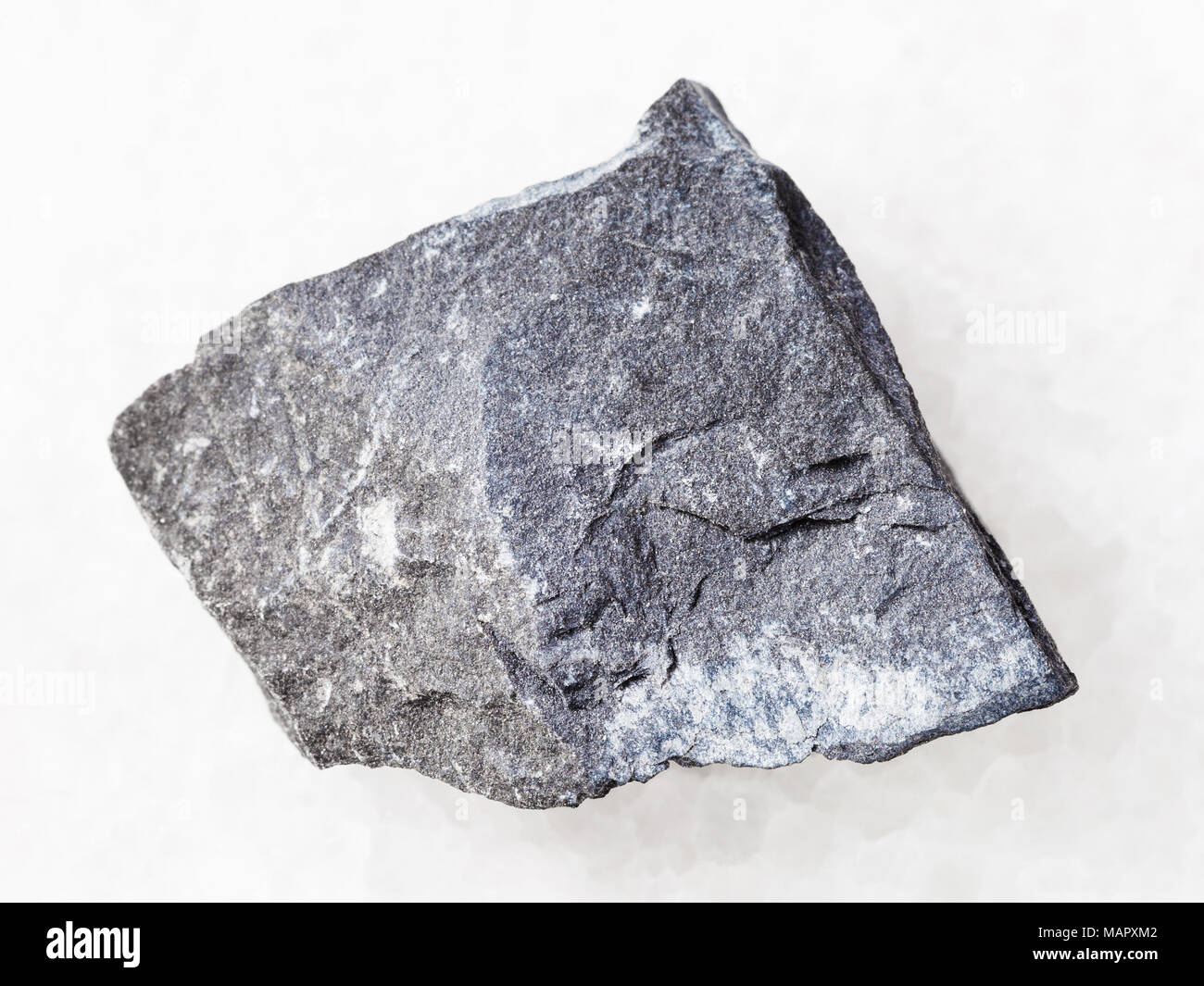 macro shooting of natural mineral rock specimen - rough argillite stone on white marble background Stock Photo