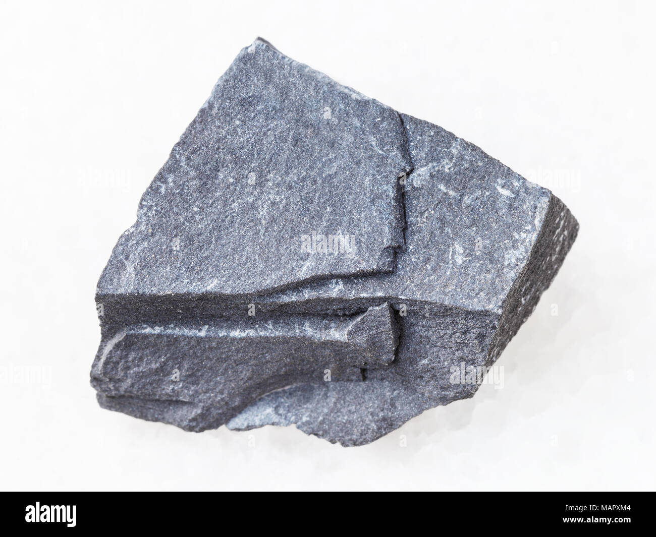 macro shooting of natural mineral rock specimen - raw argillite stone on white marble background Stock Photo