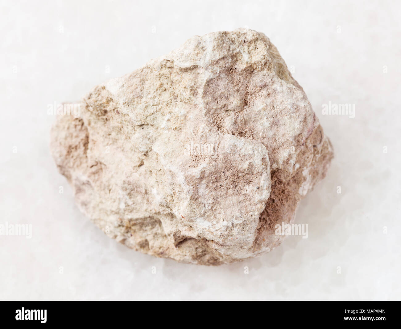 macro shooting of natural mineral rock specimen - raw marl stone on white marble background Stock Photo