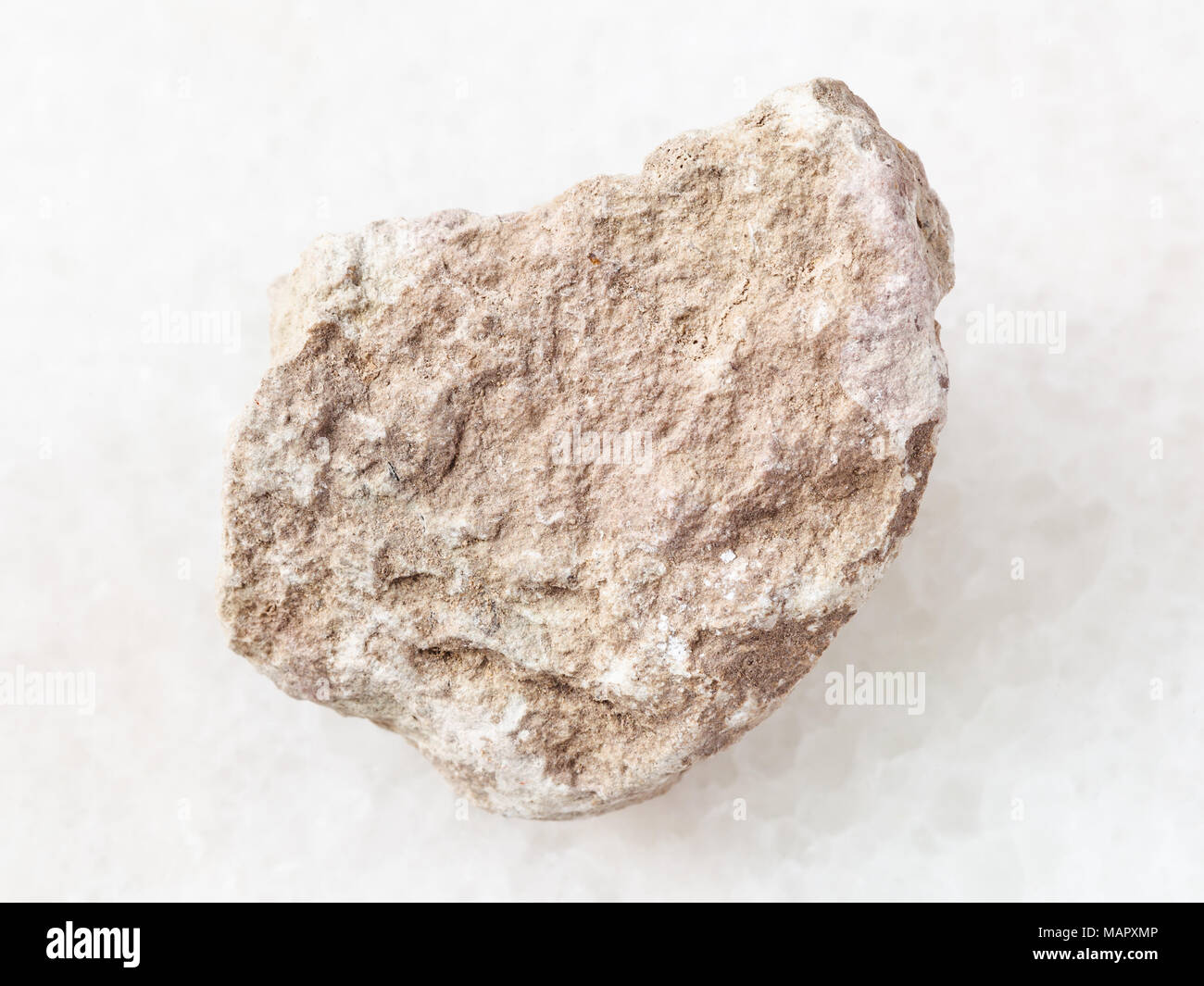macro shooting of natural mineral rock specimen - rough marl stone on white marble background Stock Photo