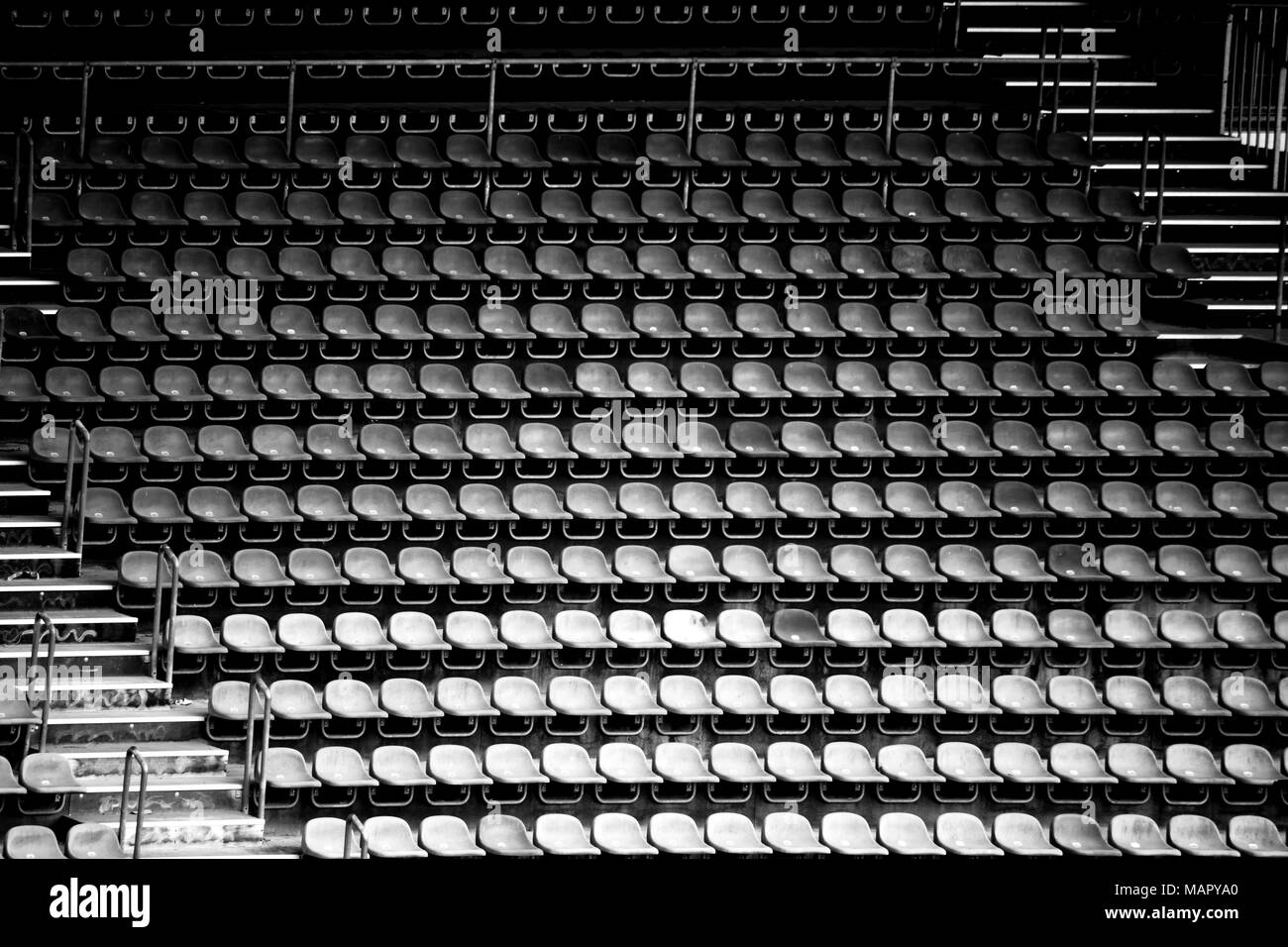 Worn rows of seats and seats in a disused stadium. Stock Photo