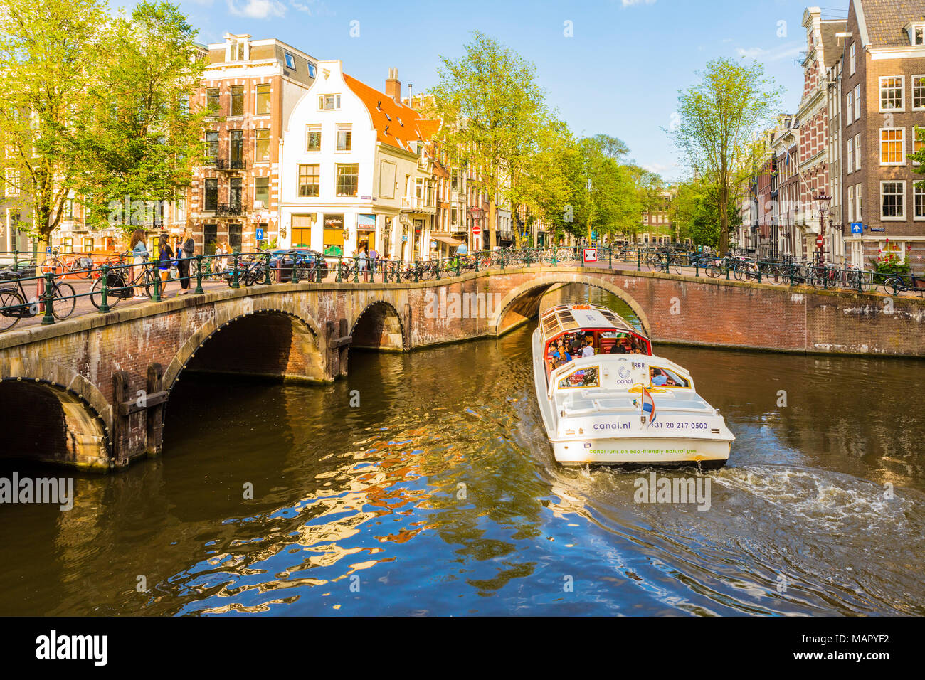 A Boat Going Under A Bridge Over The Keizersgracht Canal, Amsterdam ...