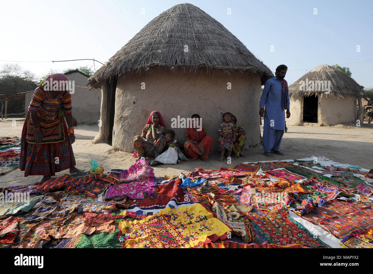 Pathan tribal family in front of traditional mud house (bhunga), showing their colourful tribal embroidery, Jarawali, Kutch, Gujarat, India, Asia Stock Photo
