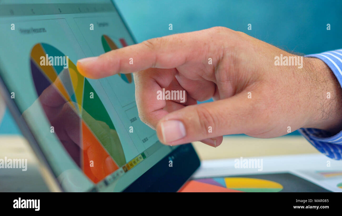 Businessman pointing and expanding graphs on modern touch screen ...