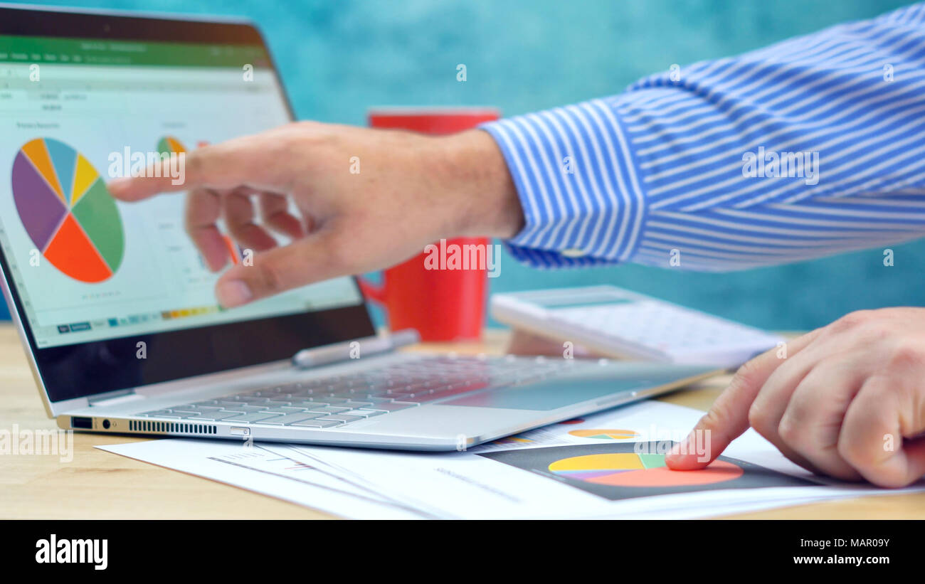 Businessman pointing and expanding graphs on modern touch screen ...