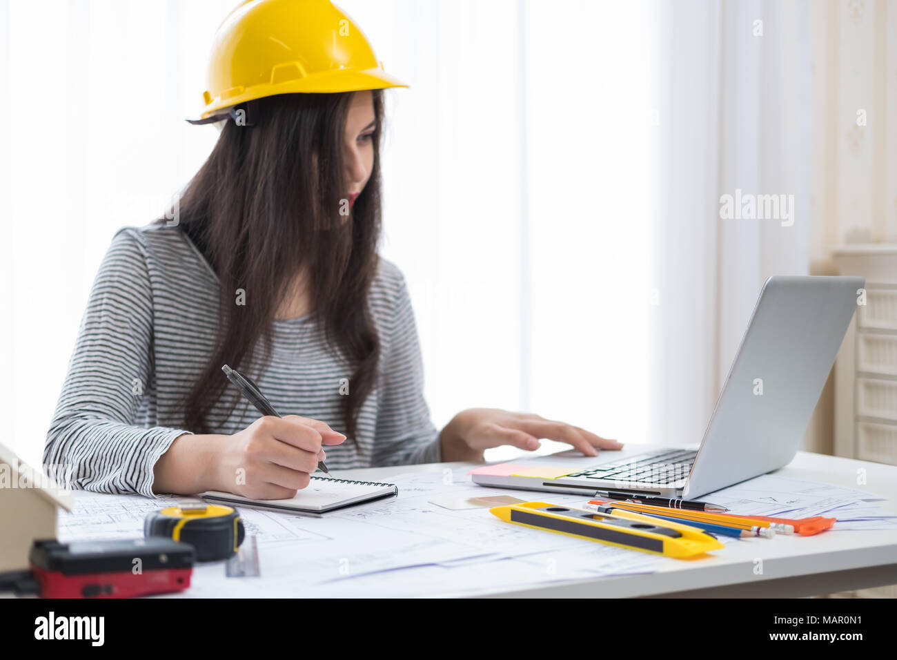 Architect or planner working on drawings for construction plans at a table Stock Photo
