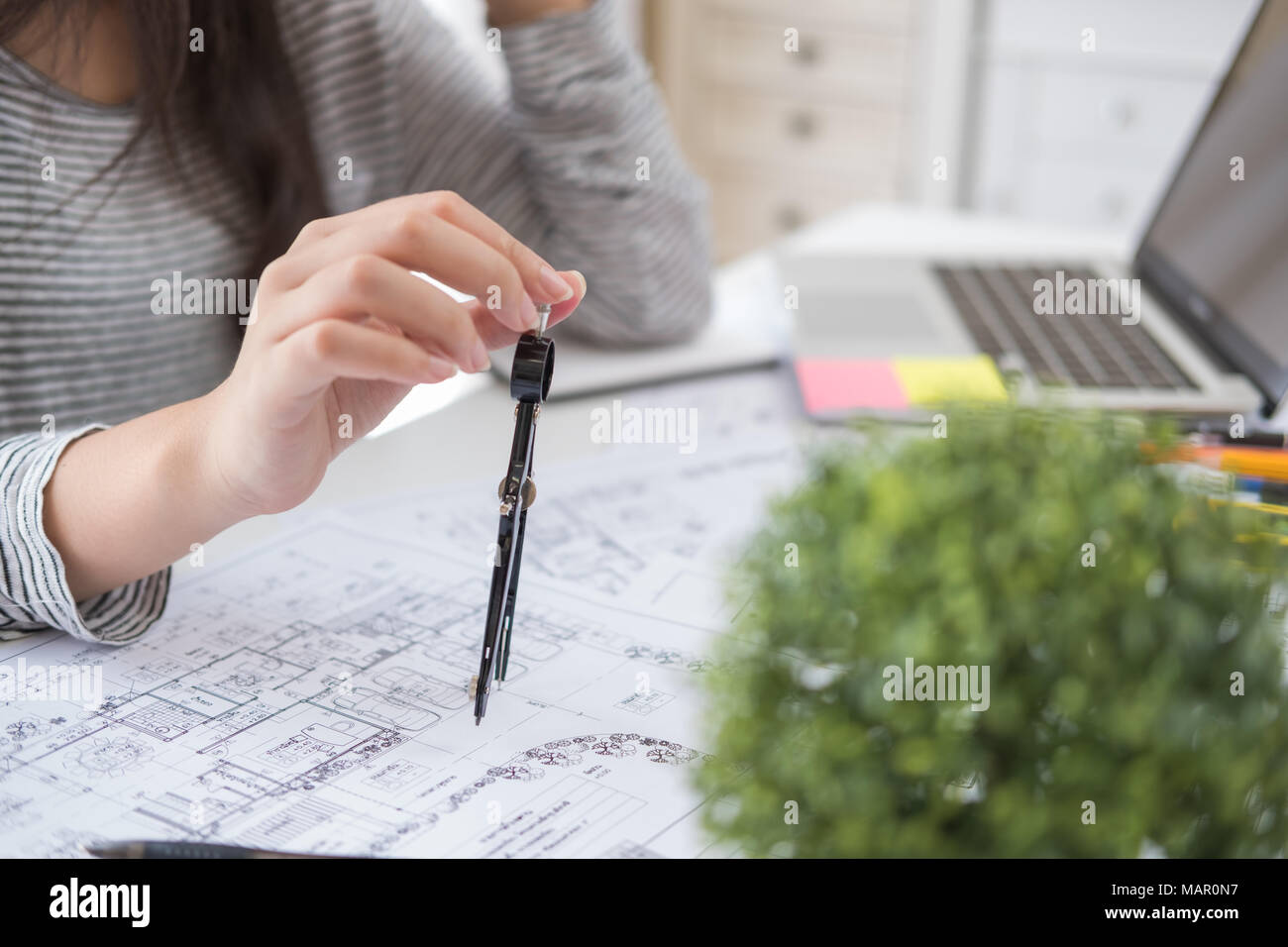 Architect or planner working on drawings for construction plans at a table Stock Photo