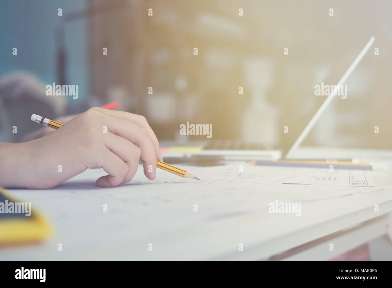 Architect or planner working on drawings for construction plans at a table Stock Photo