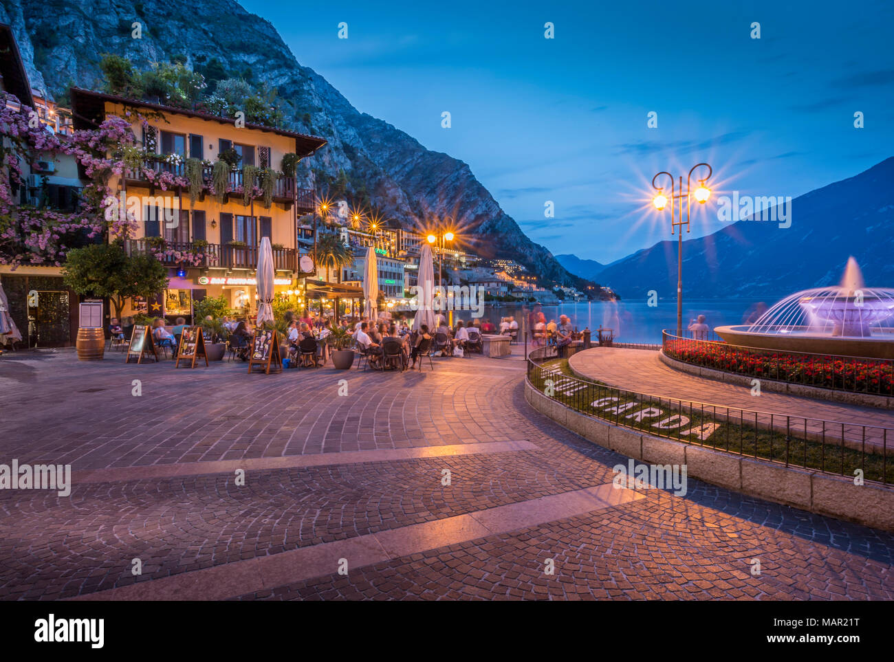 View of illuminated promenade at the port of Limone at dusk, Lake Garda, Lombardy, Italian Lakes, Italy, Europe Stock Photo