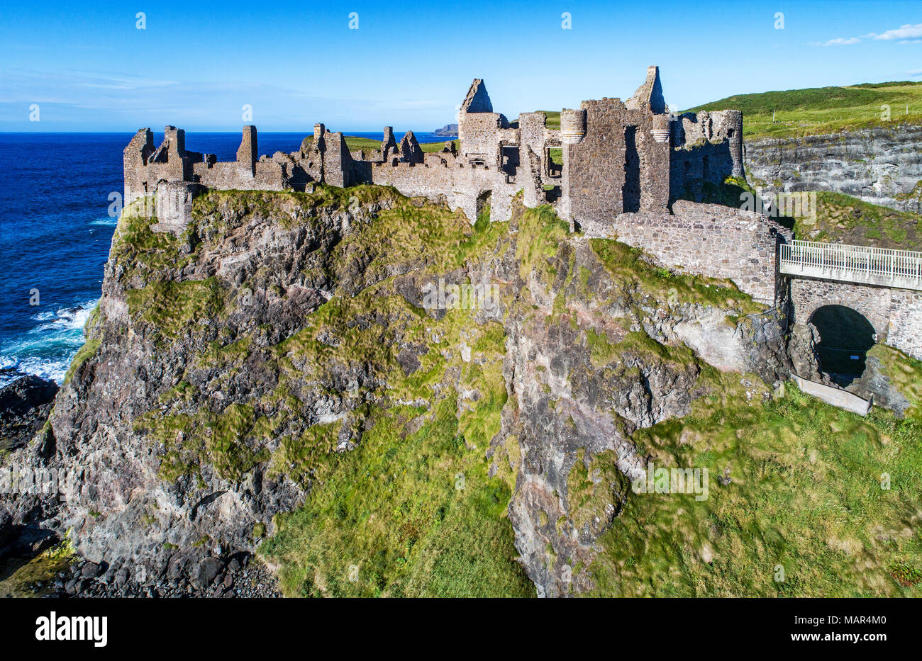 Ruins of medieval Dunluce Castle, cliffs, bays and peninsulas. Northern coast of County Antrim, Northern Ireland, UK. Aerial view. Stock Photo