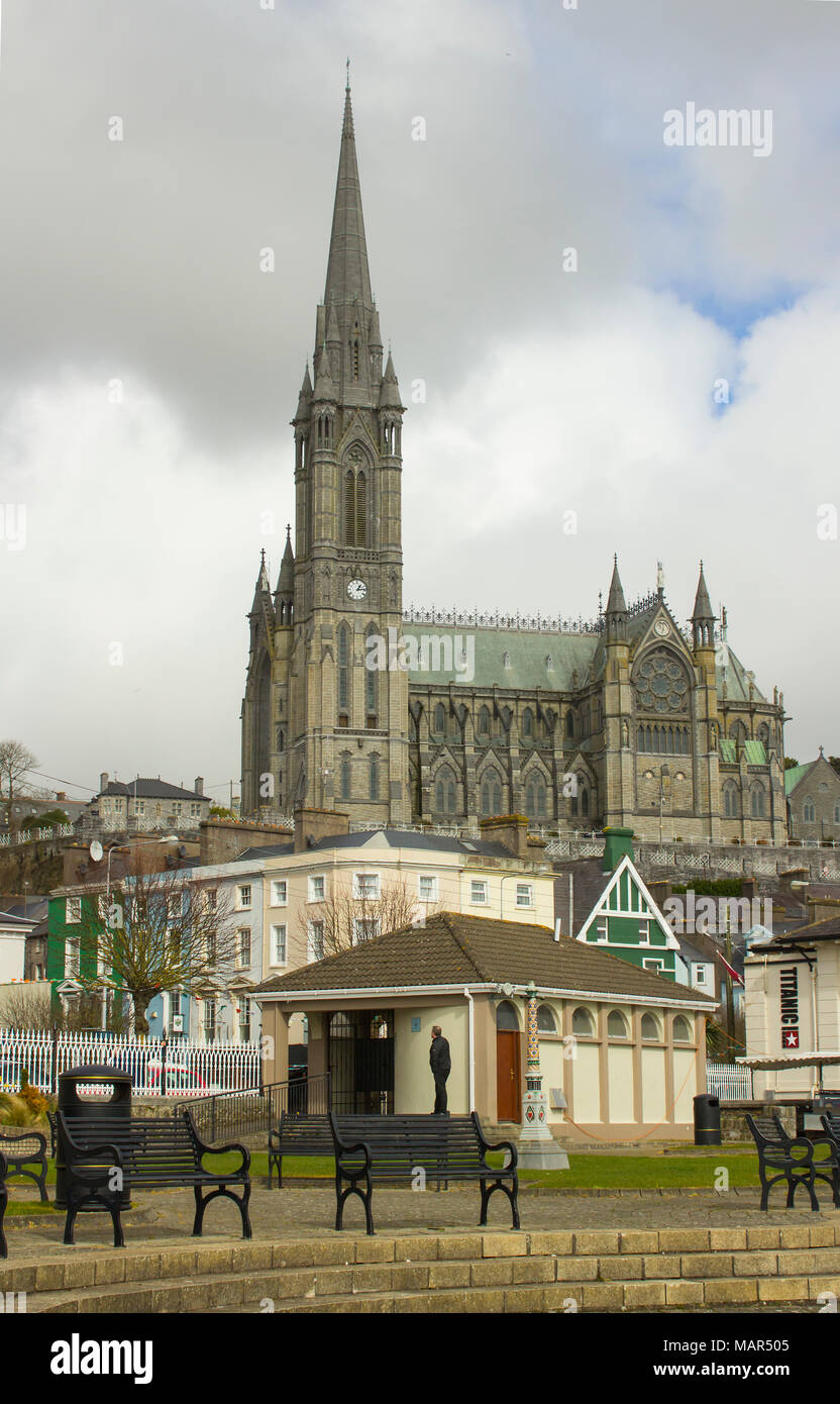 Tourists walking the seafront of Cobh in County Cork Ireland overlooked by St Colmans cathedral Stock Photo