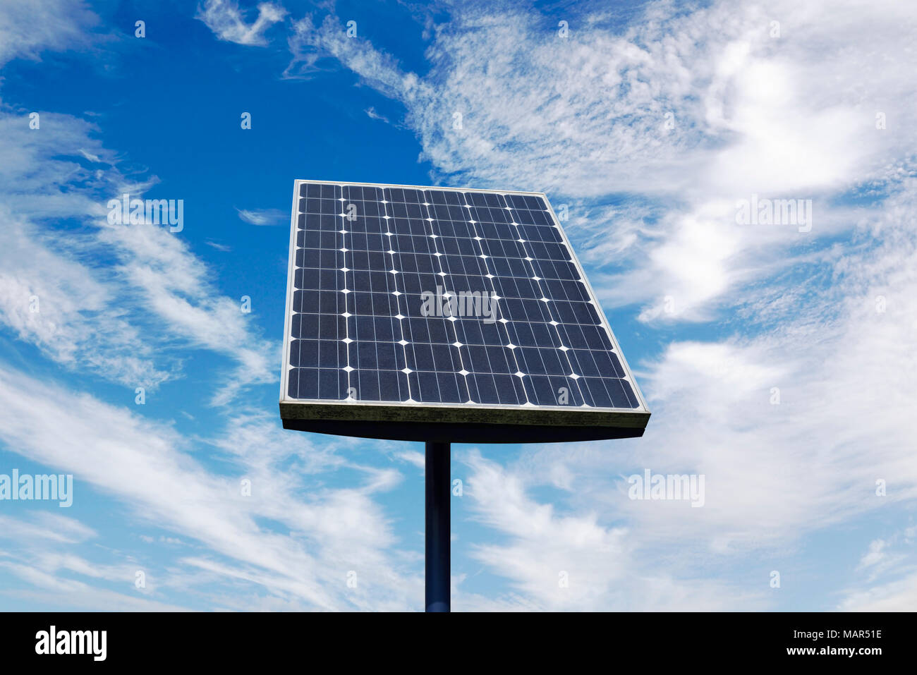 Small Solar Panel Against a Cloudy Blue Sky Stock Photo