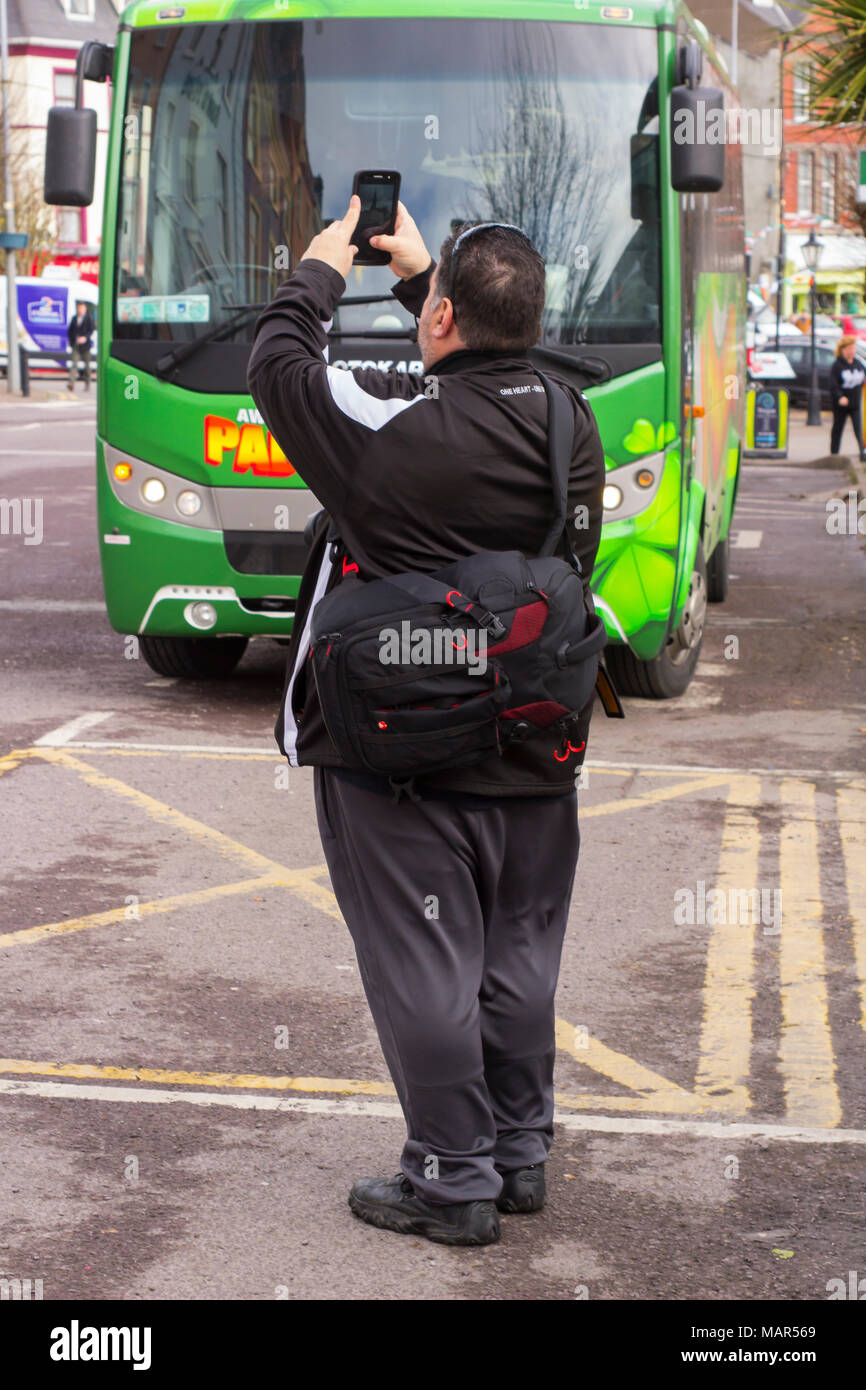 16 March 2018 A tourist taking a photograph with his mobile phone in the town of Cobh County Cork Ireland on a damp day Stock Photo