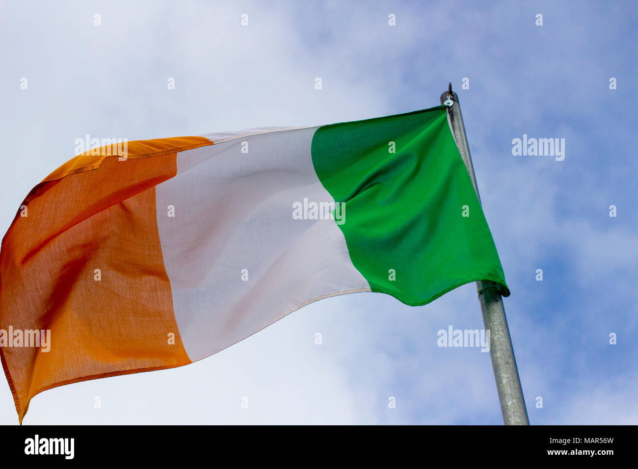 An Irish tricolour the national flag of the Republic of Ireland flying in a stiff breeze Stock Photo