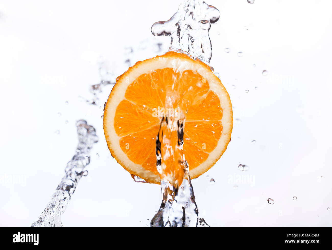 Free floating/suspended Orange with water stream or fountain Stock Photo