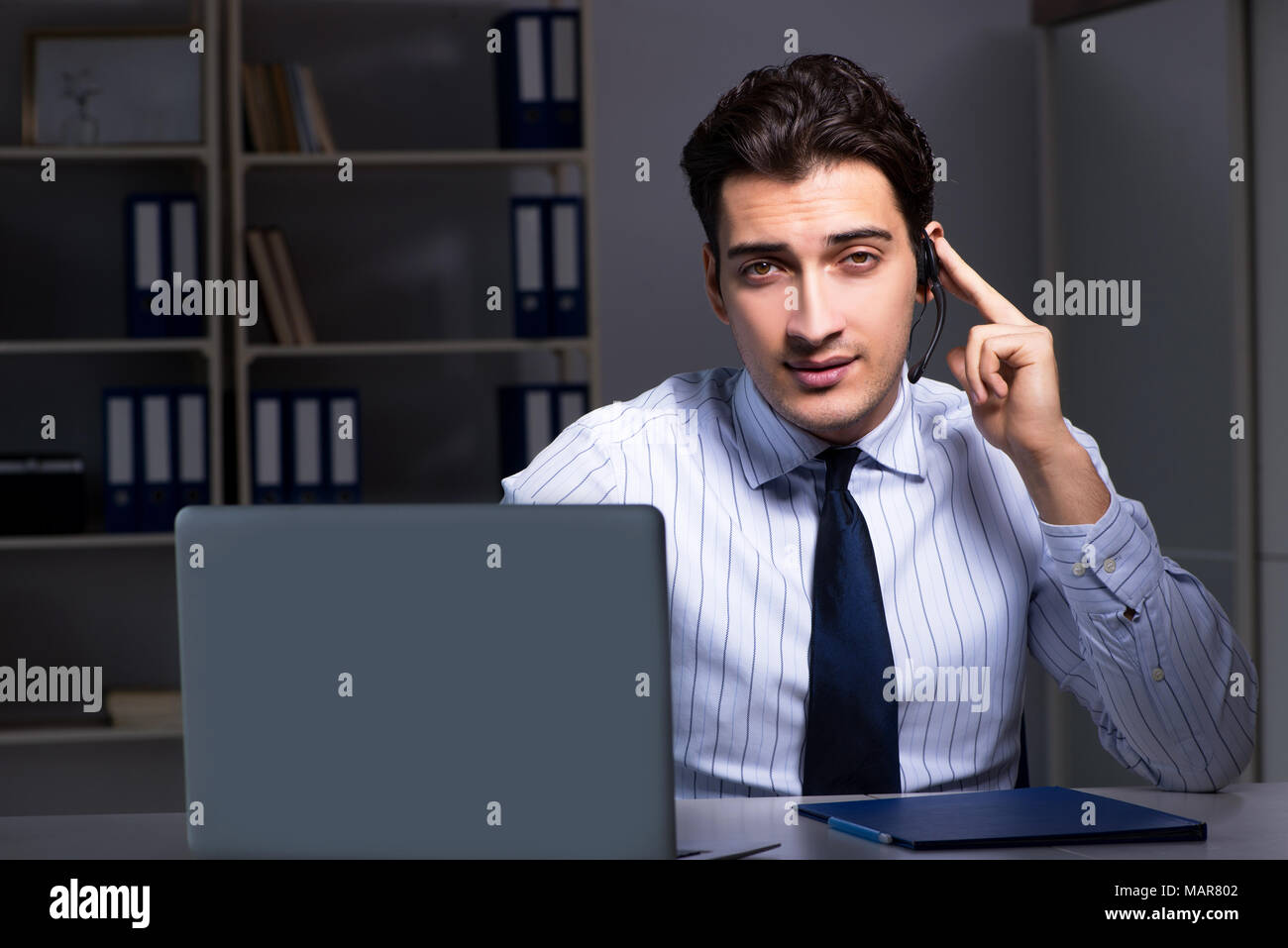 Call center operator talking to customer during night shift Stock Photo ...