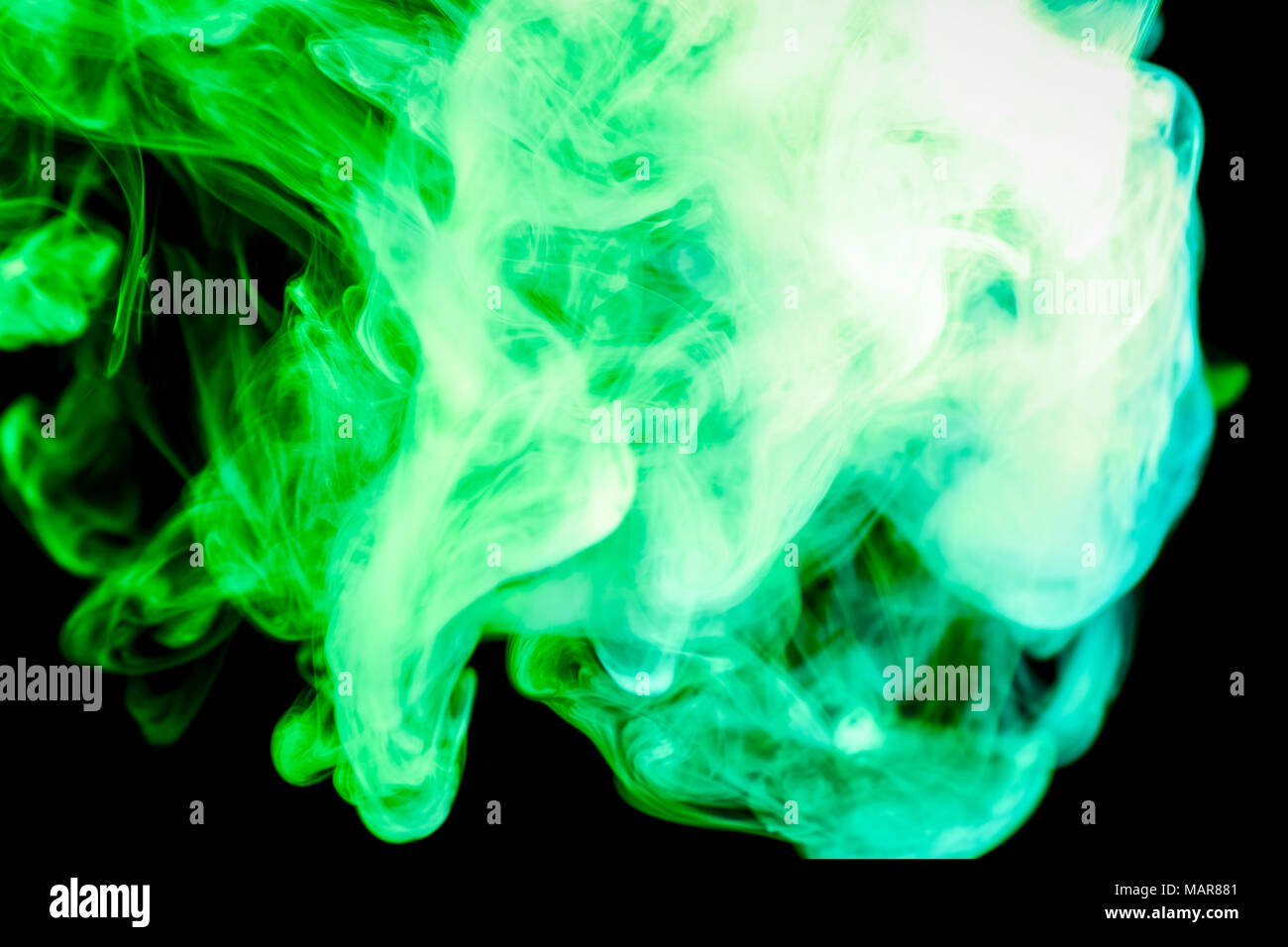 Dense green multicolored smoke on a black isolated background. Background of smoke vape Stock Photo