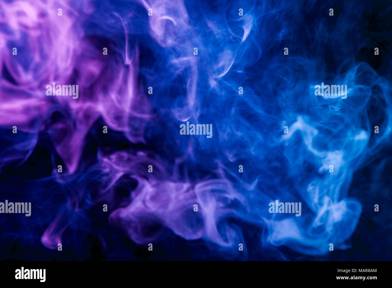Colorful  purple and blue smoke  on a black isolated background. Background from the smoke of vape Stock Photo