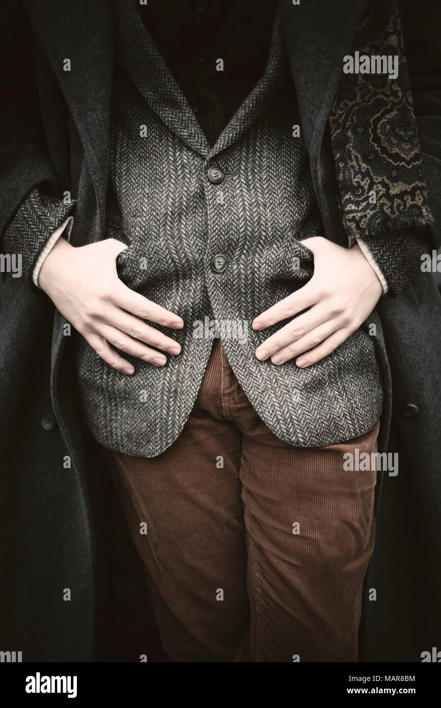 man leaning against car waiting, dressed in tweeds wearing a fedora Stock Photo