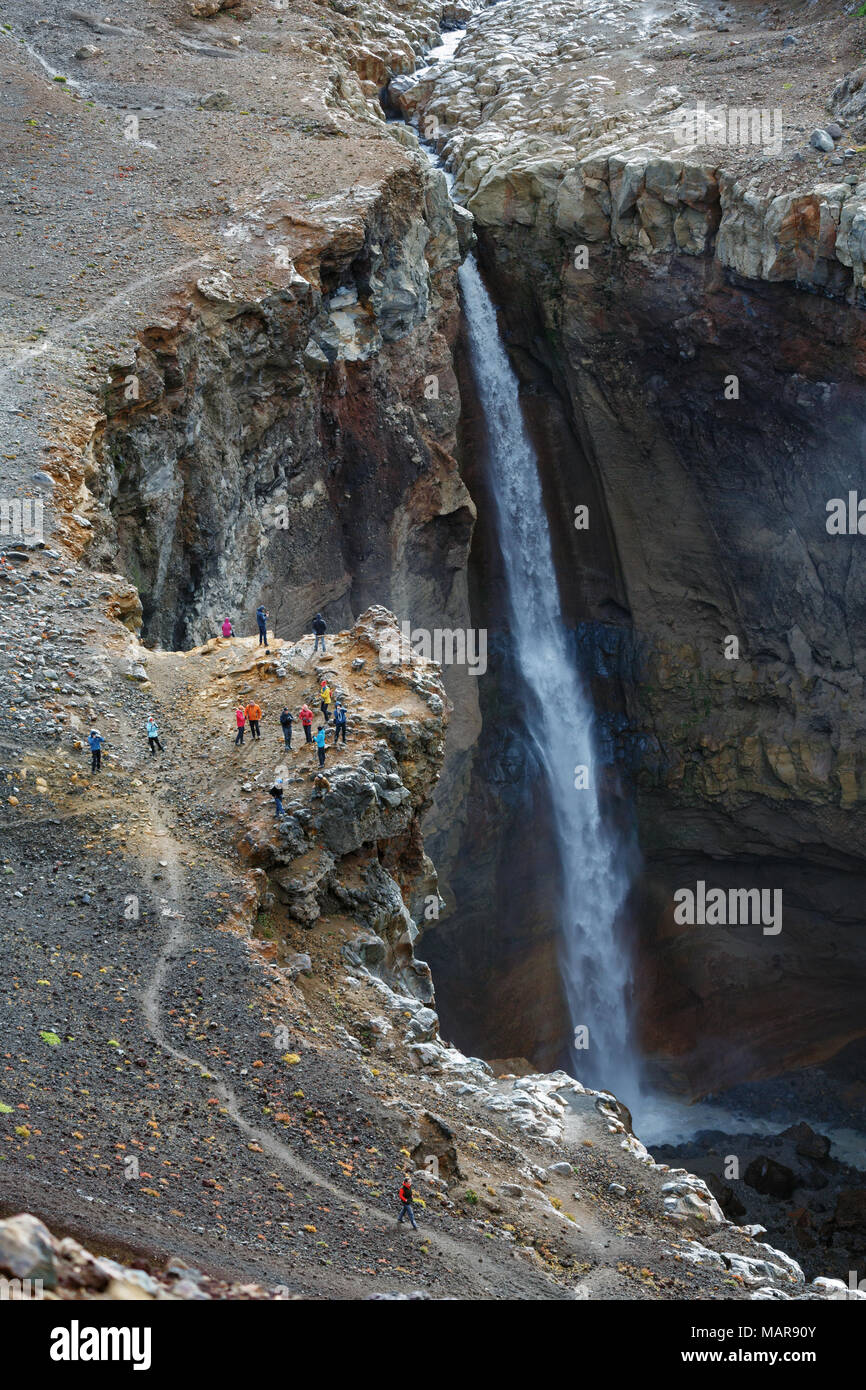 Group of travelers takes photography of powerful waterfall on mountain river in Dangerous Canyon Stock Photo