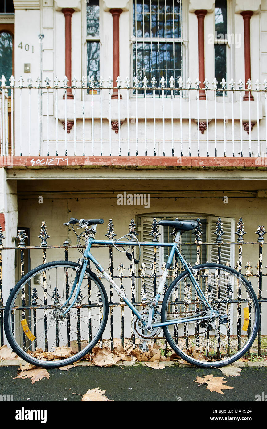 bike parked next to a fence and chained up in newcastle nsw Stock Photo