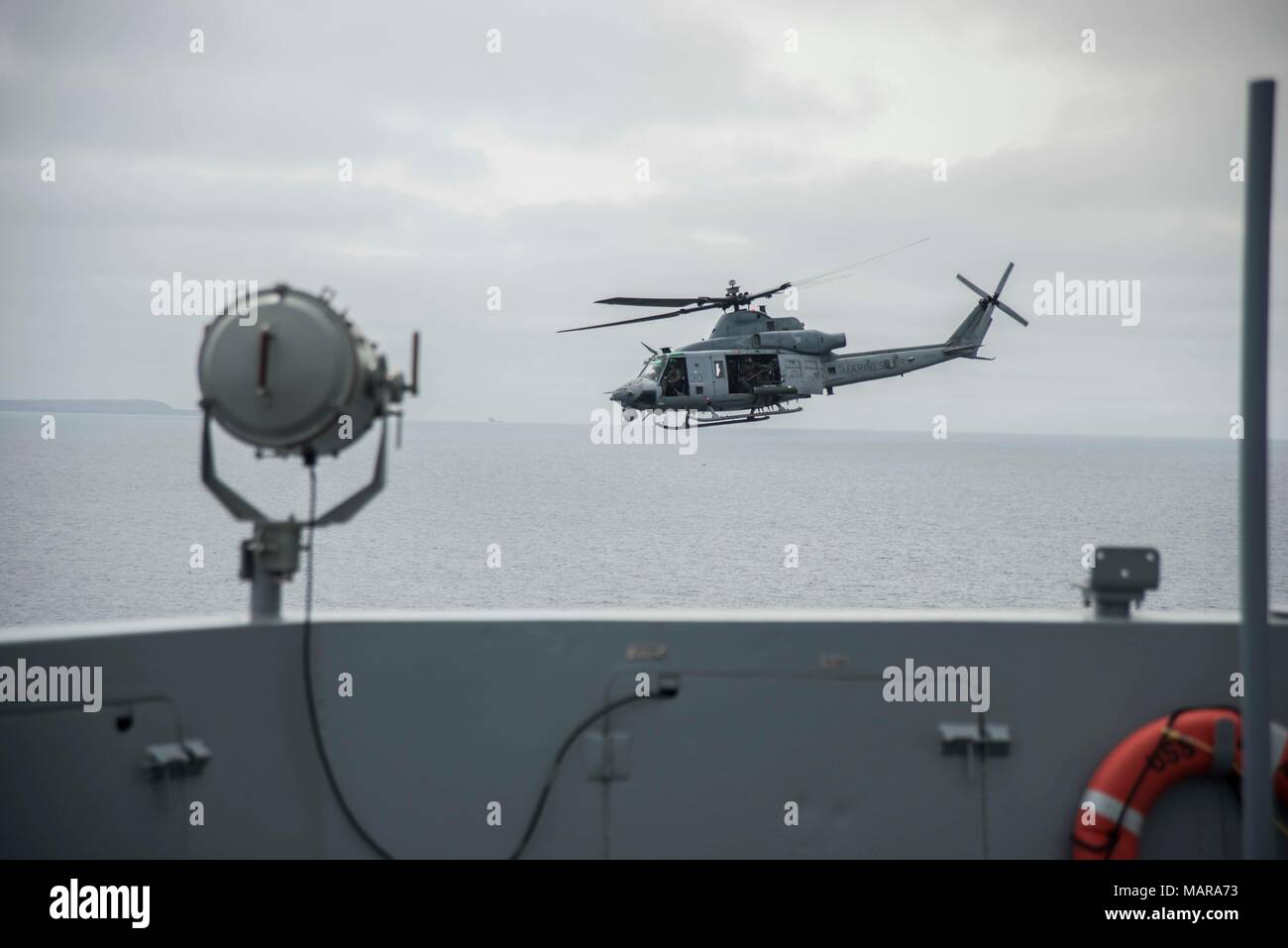 180331-N-YJ378-0106 PACIFIC OCEAN (March 31, 2018) A UH-1Y Venom helicopter attached to the Marine Light Attack Helicopter detachment of Marine Medium Tiltrotor Squadron 166, flies by San Antonio-class amphibious transport dock USS Anchorage (LPD 23), during an amphibious squadron and 13th Marine Expeditionary Unit (MEU) integration (PMINT) exercise. PMINT is a training evolution between Essex Amphibious Ready Group and 13th MEU, which allows Sailors and Marines to train as a cohesive unit in preparation for their upcoming deployment. (U.S. Navy photo by Mass Communication Specialist 2nd Class Stock Photo