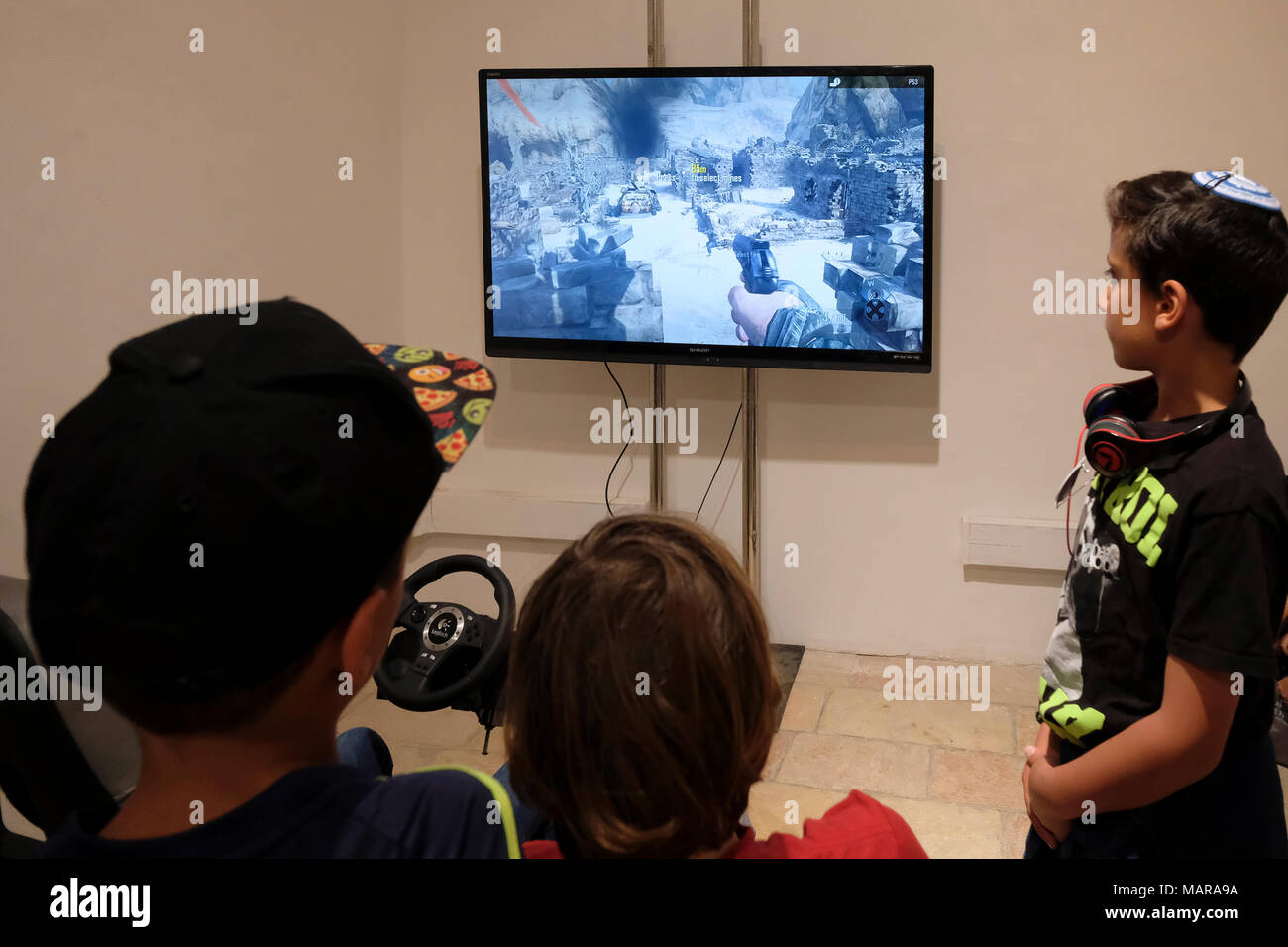 Israeli children playing violent simulated war video game with a  PlayStation 3 (PS3) console in Jerusalem Israel Stock Photo - Alamy