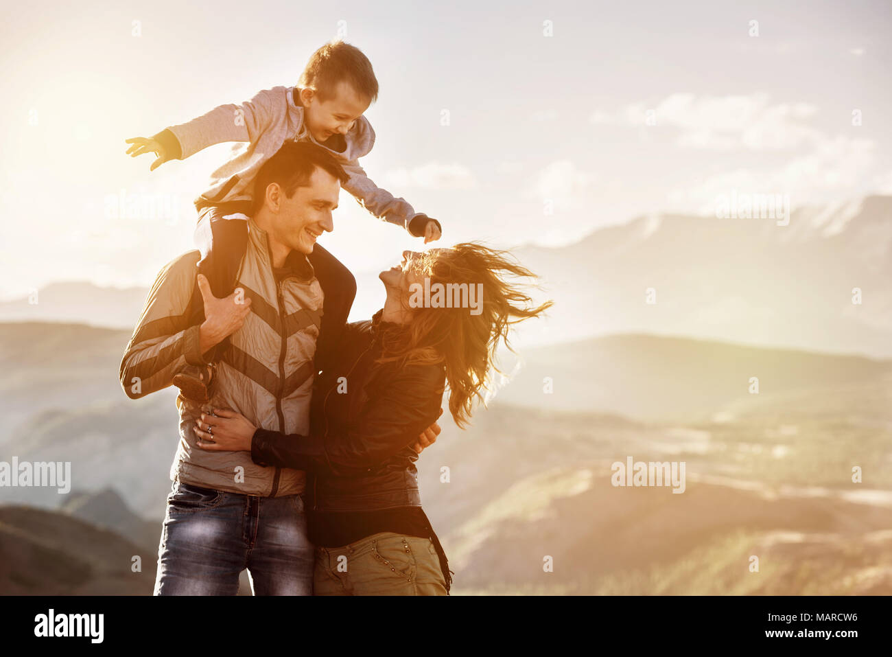 Falimy with little child is walking at sunset time in mountains area Stock Photo