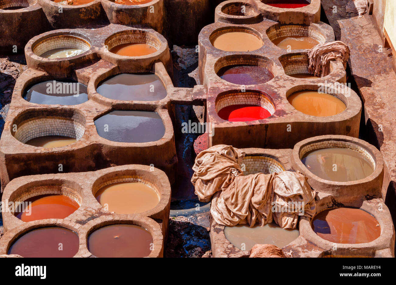 MOROCCO FES MEDINA SOUK CHOUWARA TANNERY TANNERIES CIRCULAR VATS OR TANKS WITH COLOURED DYES CONTAINING THE HIDES VARIETY OF COLOUR Stock Photo