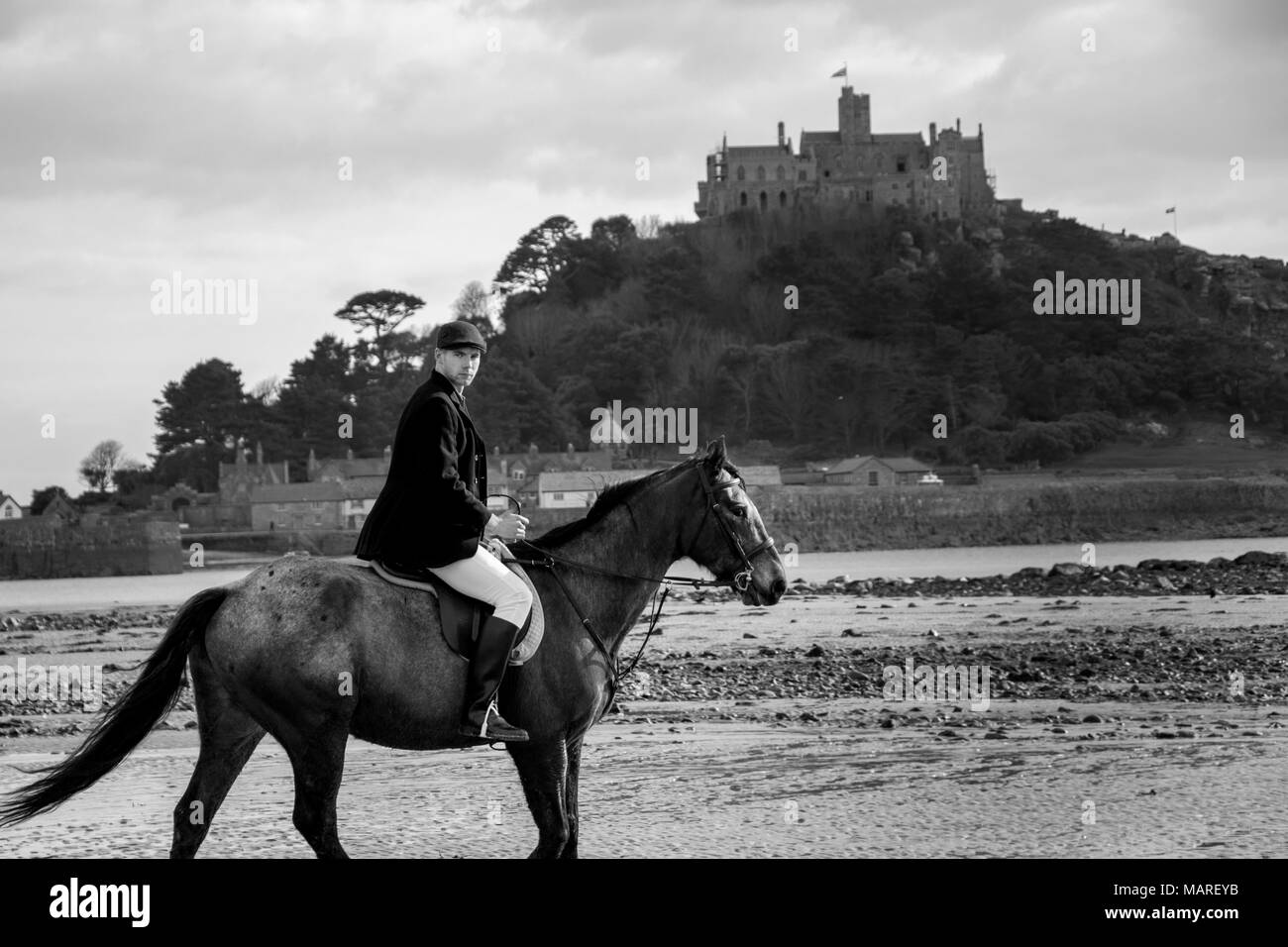 Handsome Male Horse Rider on horseback, wearing flat cap, white trousers and black boots Stock Photo