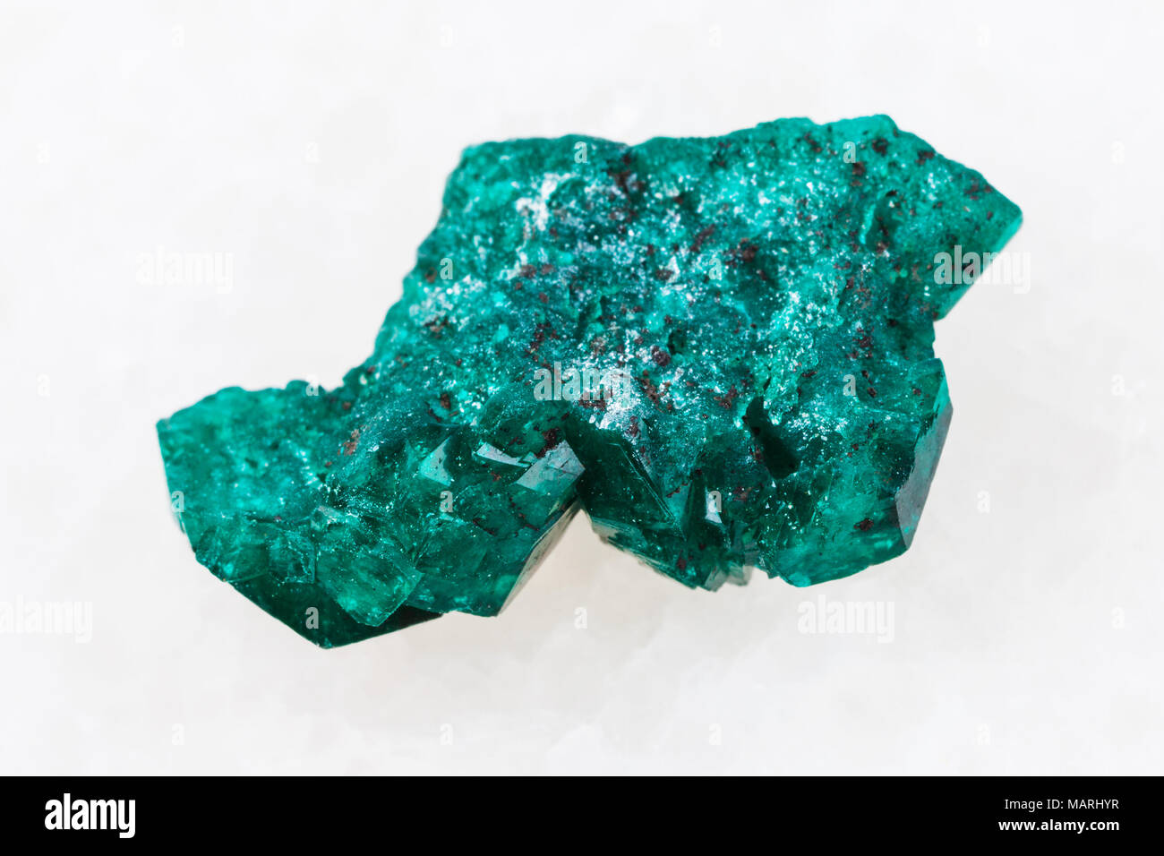 macro shooting of natural mineral rock specimen - Dioptase crystal of gemstone on white marble background from Altyn-Tyube mine, Karaganda region, Kaz Stock Photo