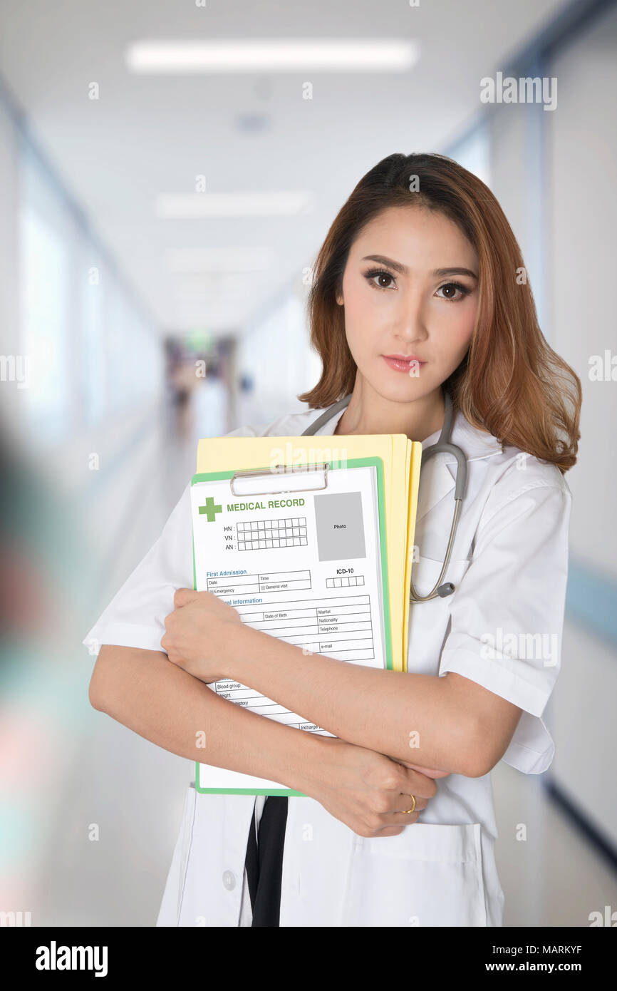 Female doctor holding blank medical record and file folder in her arms