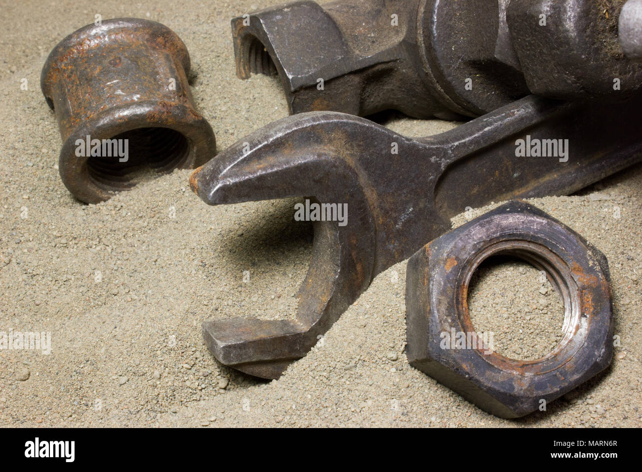 Old wrench and nuts on the sand Stock Photo